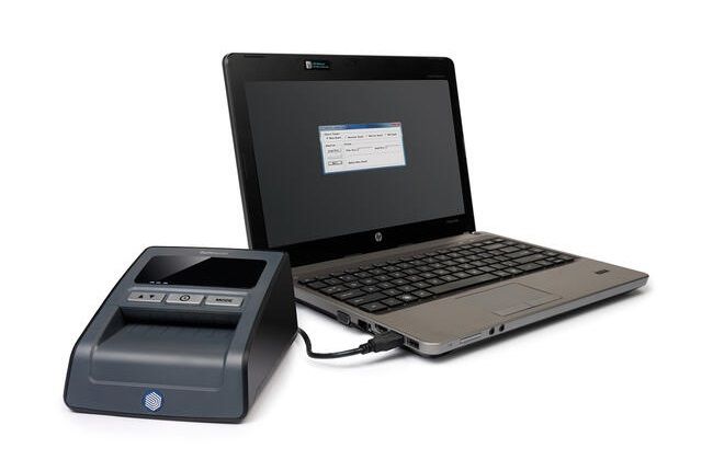 Banknote verifier connected to laptop via USB port